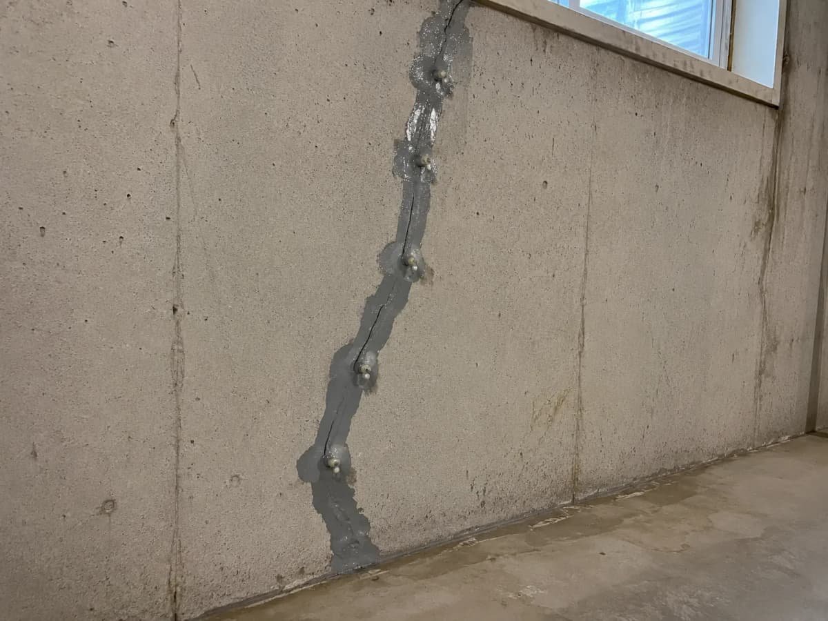 Foundation crack sealed with injection ports along a poured concrete basement wall
